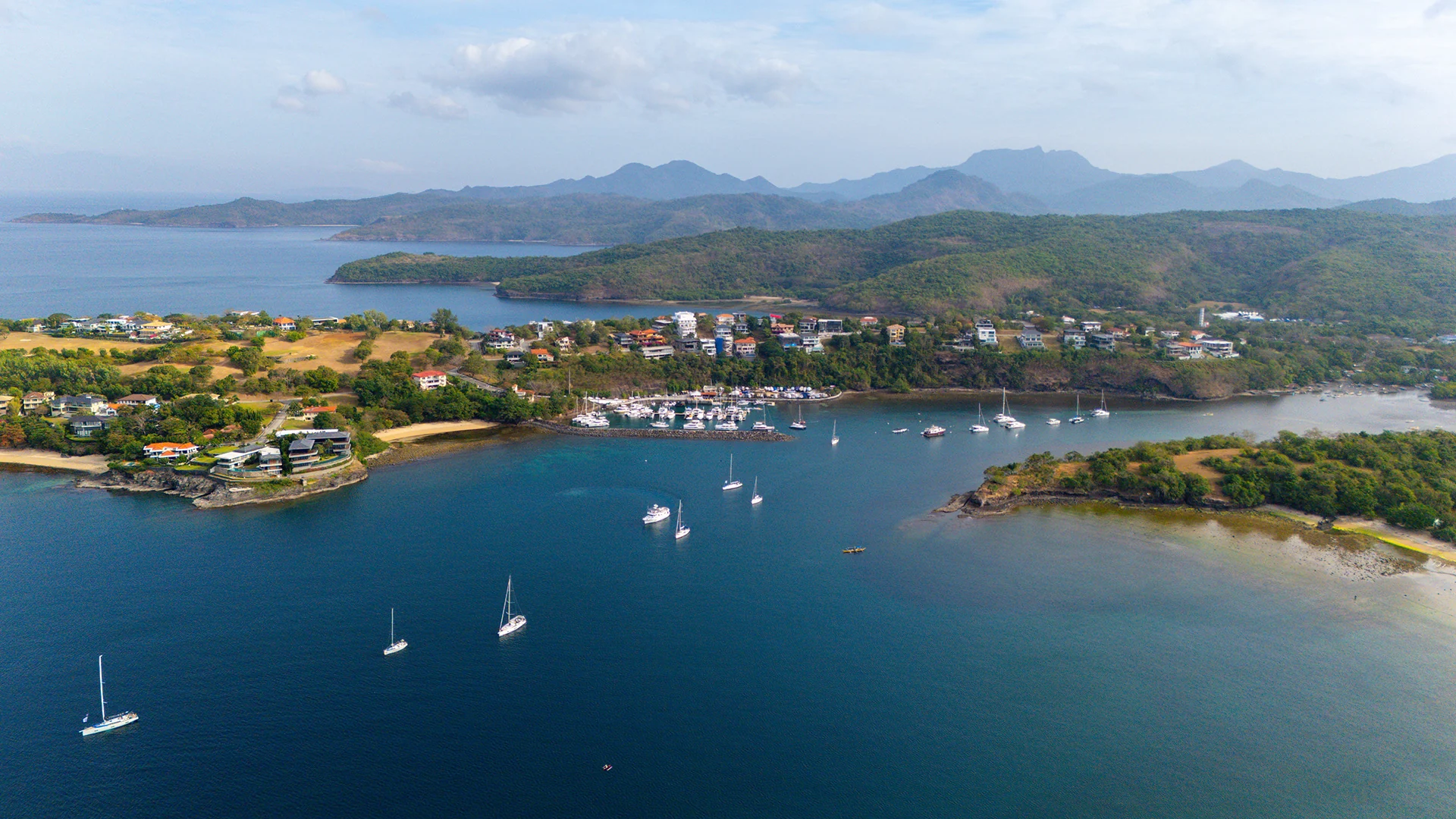 Aerial view of a Philippine marina with yachts anchored in a sheltered bay